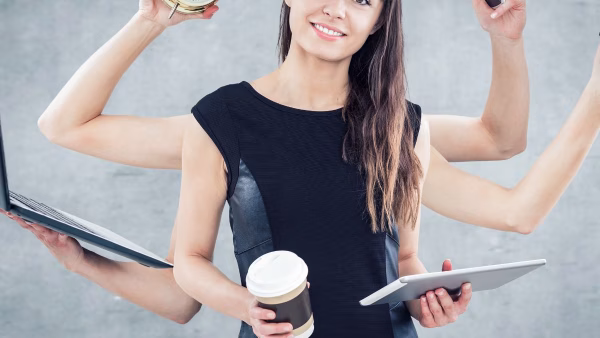 vrouw die aan het werk is en meerdere dingen tegelijkertijd vasthoudt, aan het multitasken is